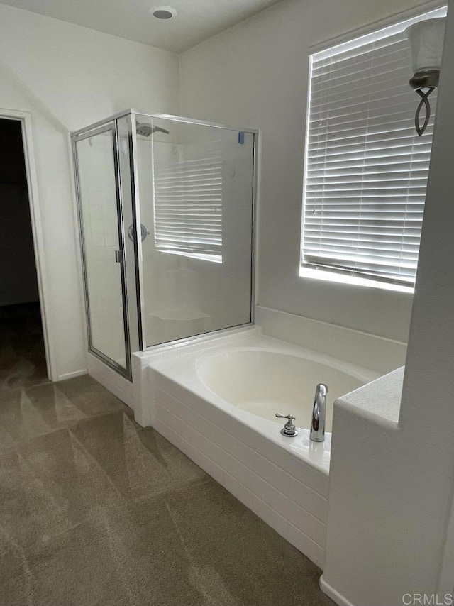 bathroom featuring a shower stall and a bath