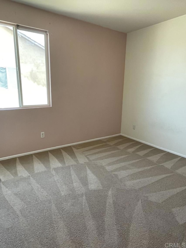 carpeted spare room with baseboards