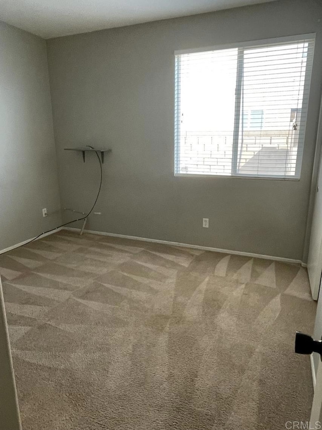 empty room featuring carpet flooring and baseboards