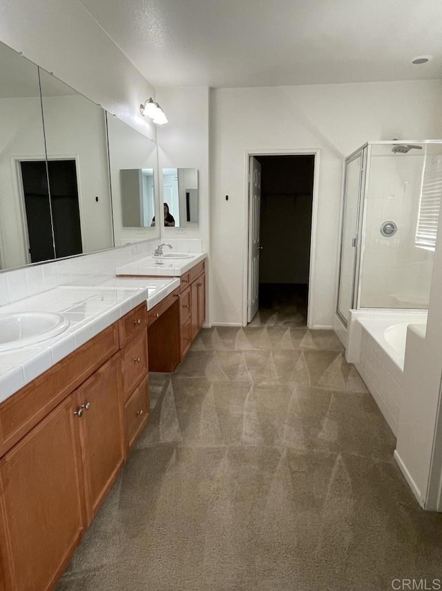 bathroom featuring a tub, a stall shower, a sink, and double vanity