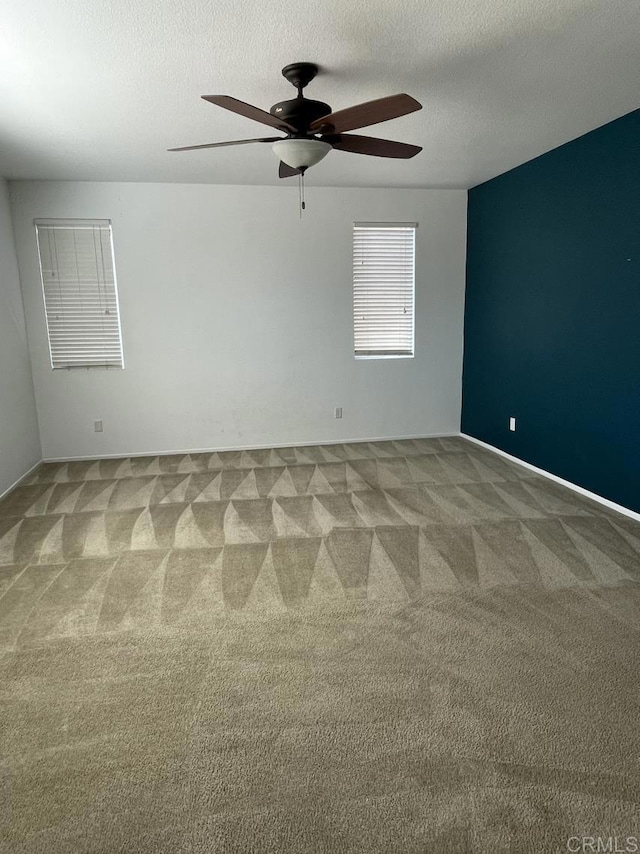 empty room with carpet floors, a textured ceiling, and a ceiling fan