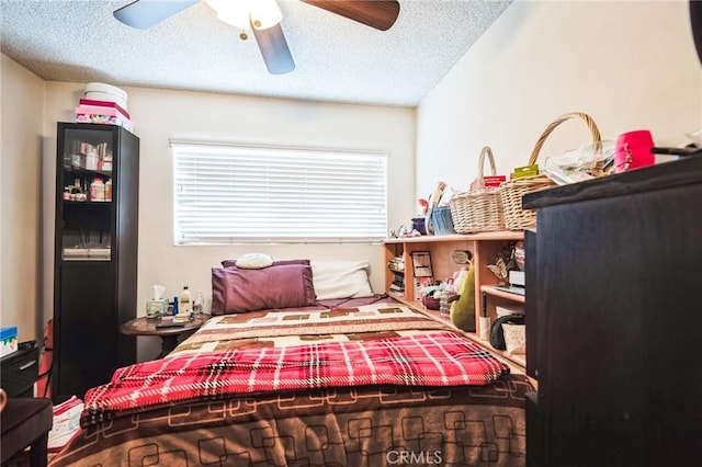 bedroom featuring a ceiling fan and a textured ceiling