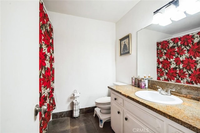 bathroom with toilet, tile patterned floors, baseboards, and vanity