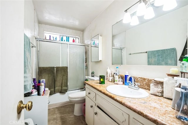 full bath with enclosed tub / shower combo, vanity, and toilet