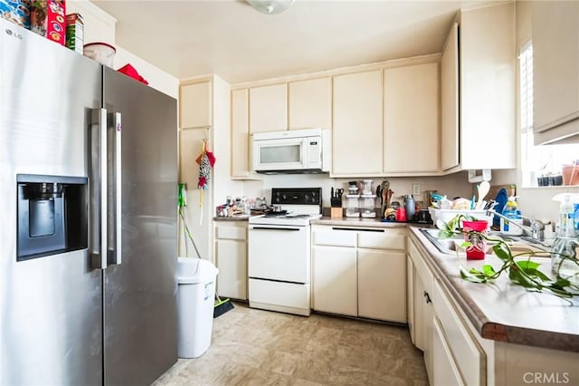 kitchen with light countertops, white appliances, a sink, and cream cabinetry