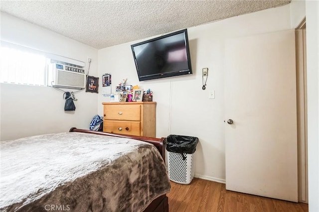 bedroom featuring a textured ceiling and wood finished floors