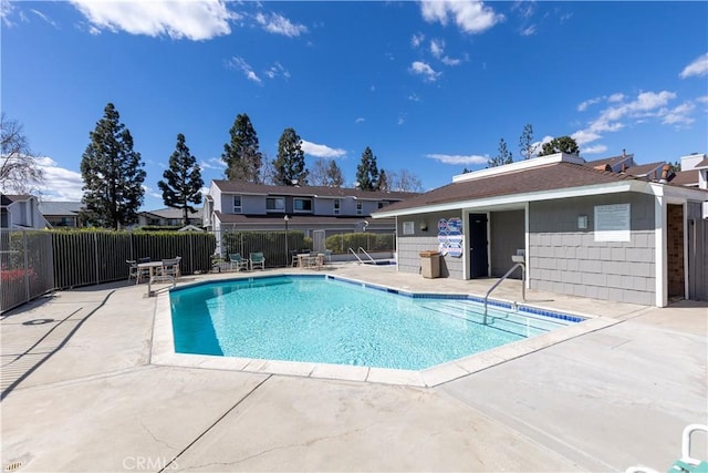 community pool with a patio and fence