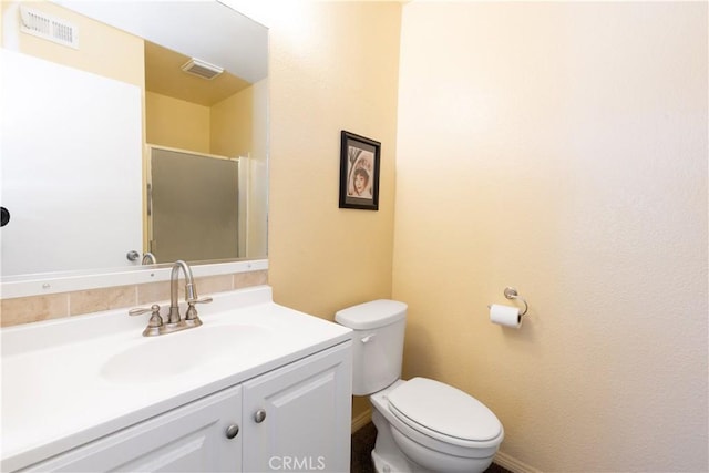 bathroom with a stall shower, visible vents, vanity, and toilet