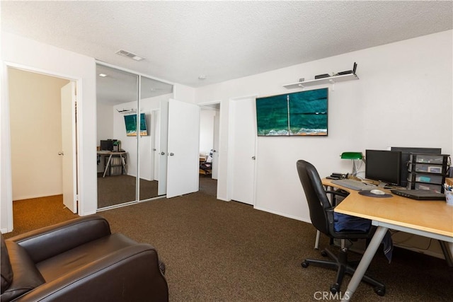 home office featuring carpet, visible vents, and a textured ceiling