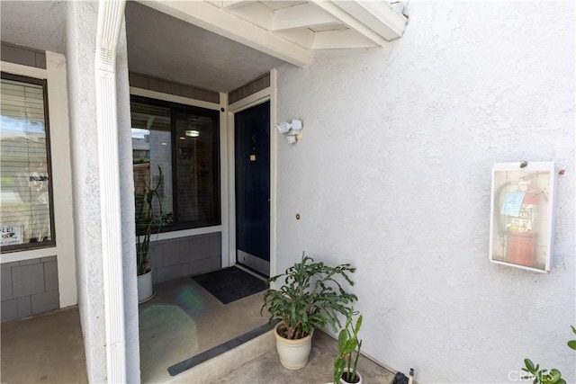 doorway to property featuring stucco siding