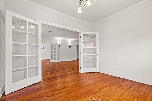 unfurnished room featuring wood finished floors, french doors, baseboards, and ornamental molding