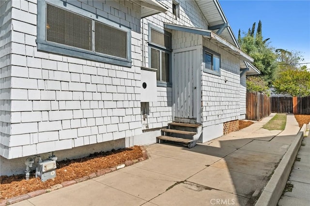 entrance to property featuring fence and crawl space