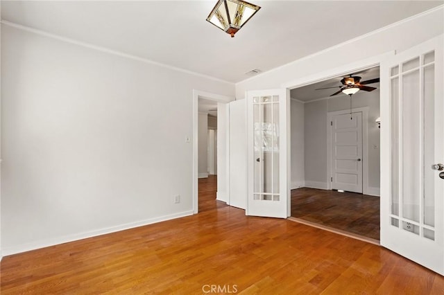 unfurnished room featuring light wood-style flooring, french doors, visible vents, and baseboards