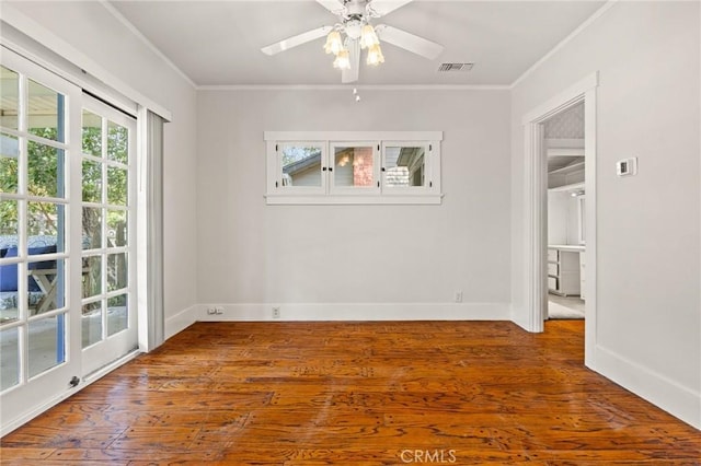 unfurnished room with baseboards, wood finished floors, visible vents, and ornamental molding