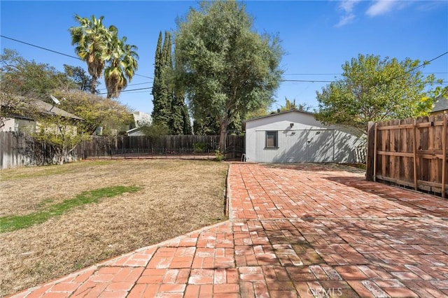 view of yard featuring an outbuilding, a fenced backyard, and a patio area