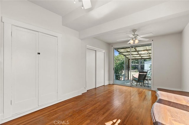 unfurnished bedroom with a ceiling fan, wood finished floors, baseboards, a sunroom, and access to exterior