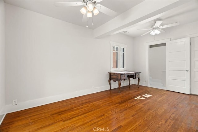 unfurnished bedroom featuring beamed ceiling, ceiling fan, baseboards, and wood finished floors