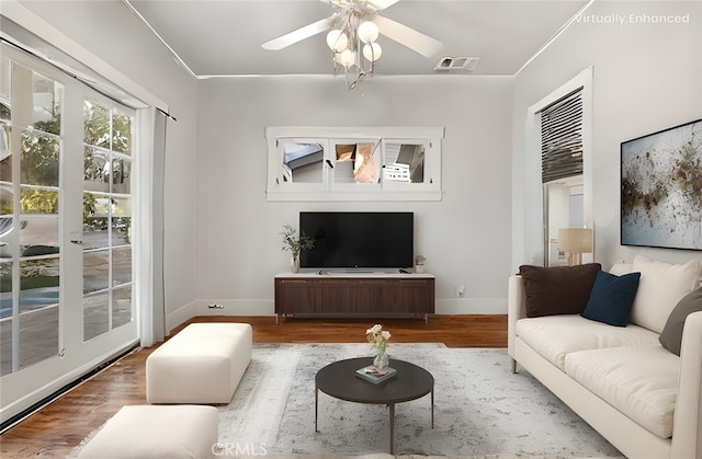 living room featuring ceiling fan, wood finished floors, visible vents, and baseboards