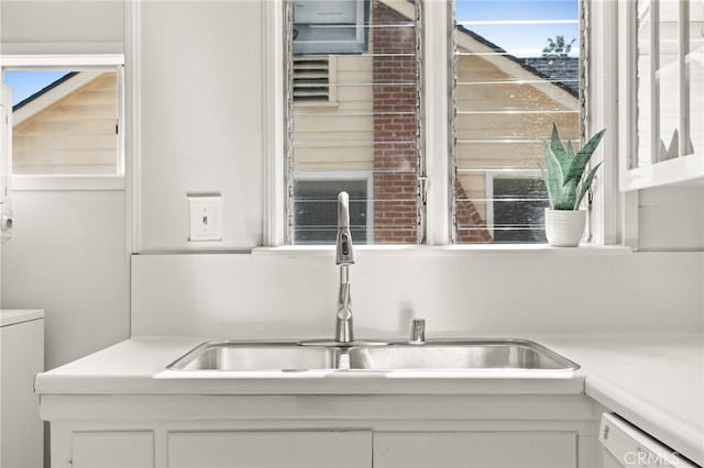 interior details with a hot tub, dishwasher, light countertops, white cabinetry, and a sink