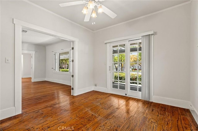 interior space with a ceiling fan, crown molding, baseboards, and hardwood / wood-style floors