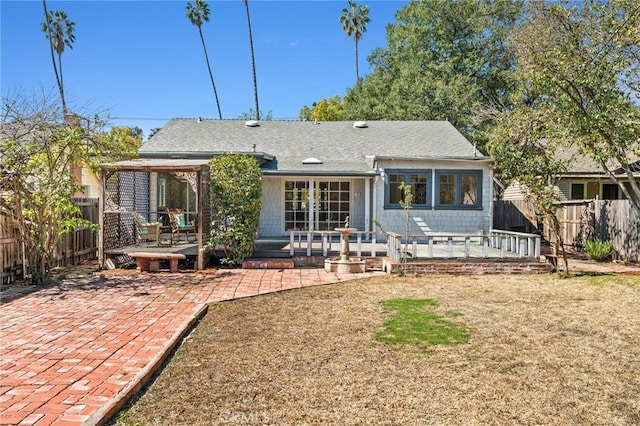 rear view of house featuring french doors, a patio, roof with shingles, and fence