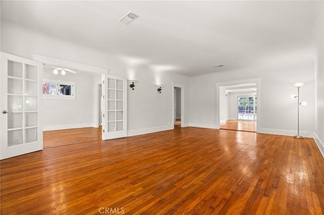 spare room with hardwood / wood-style flooring, french doors, visible vents, and baseboards