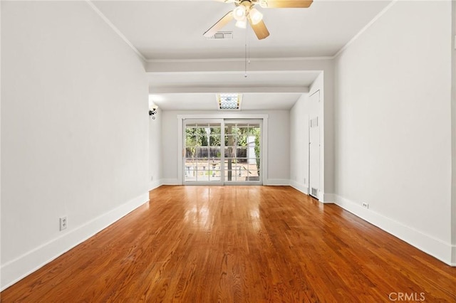 unfurnished living room featuring visible vents, wood finished floors, crown molding, baseboards, and ceiling fan