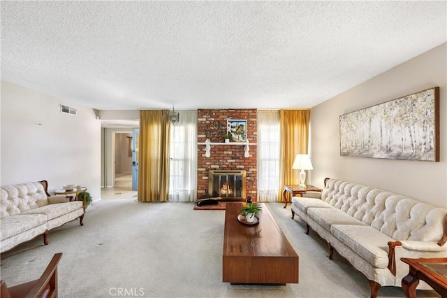 living area with a textured ceiling, a brick fireplace, carpet flooring, and visible vents