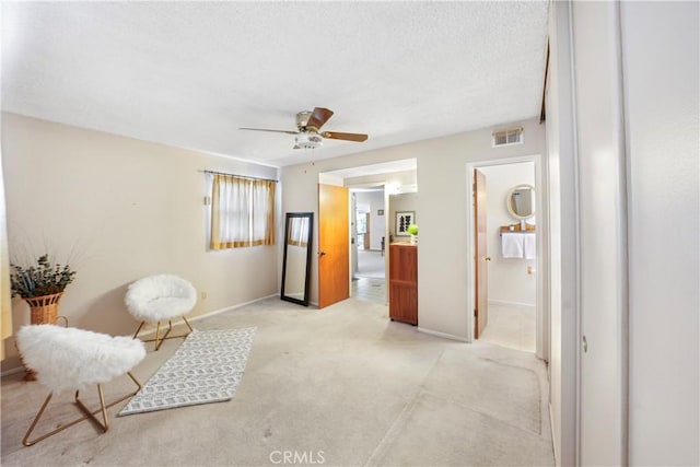 sitting room with ceiling fan, visible vents, and baseboards