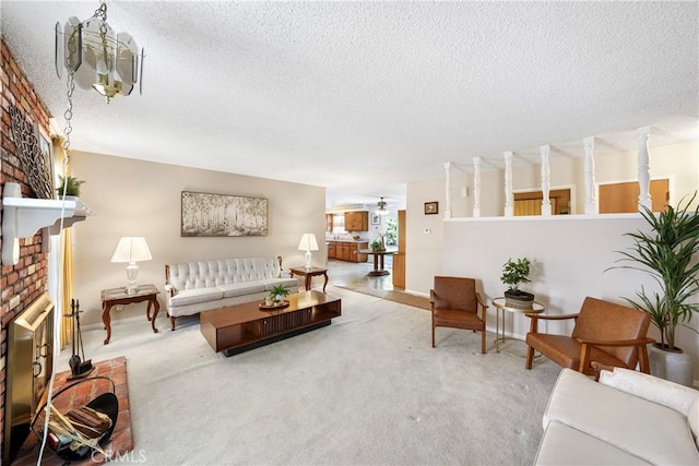 living room featuring a textured ceiling, carpet, a fireplace, and a ceiling fan