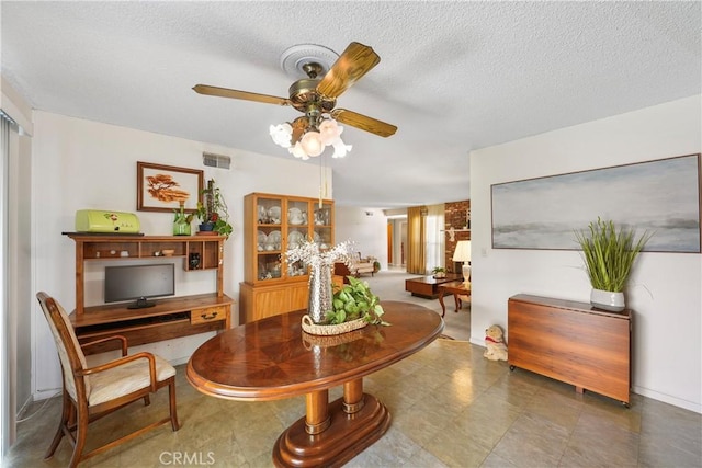 sitting room with visible vents, ceiling fan, and a textured ceiling