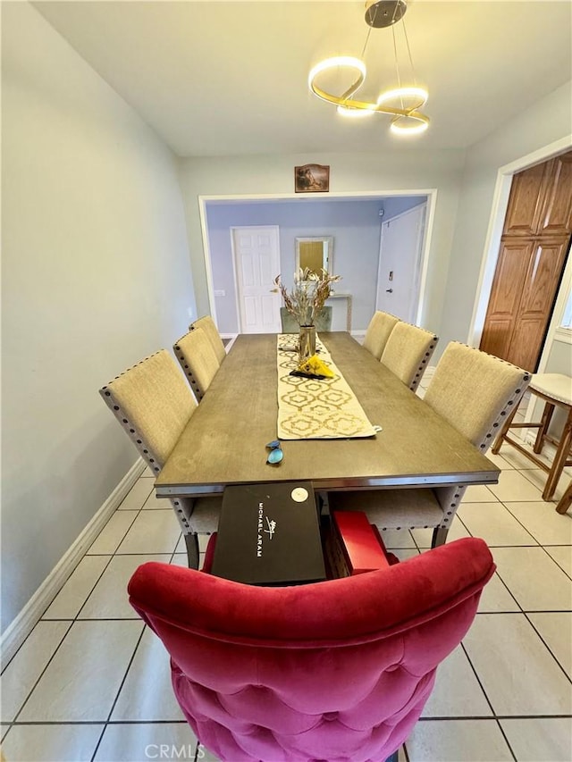 dining room with light tile patterned floors, baseboards, and a chandelier