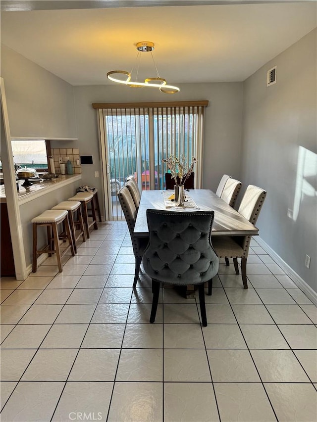 dining space with a chandelier, visible vents, baseboards, and light tile patterned flooring