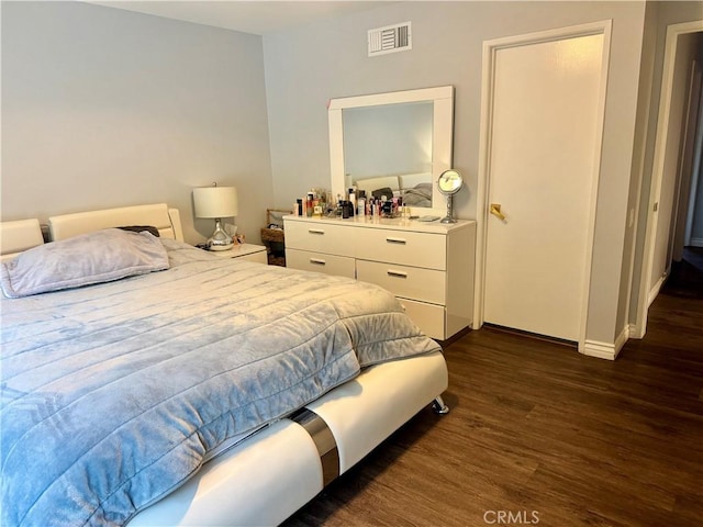 bedroom featuring visible vents, dark wood finished floors, and baseboards