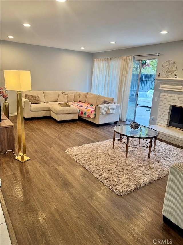 living area featuring dark wood-type flooring, recessed lighting, and a fireplace