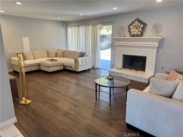 living room featuring recessed lighting, baseboards, wood finished floors, and a fireplace