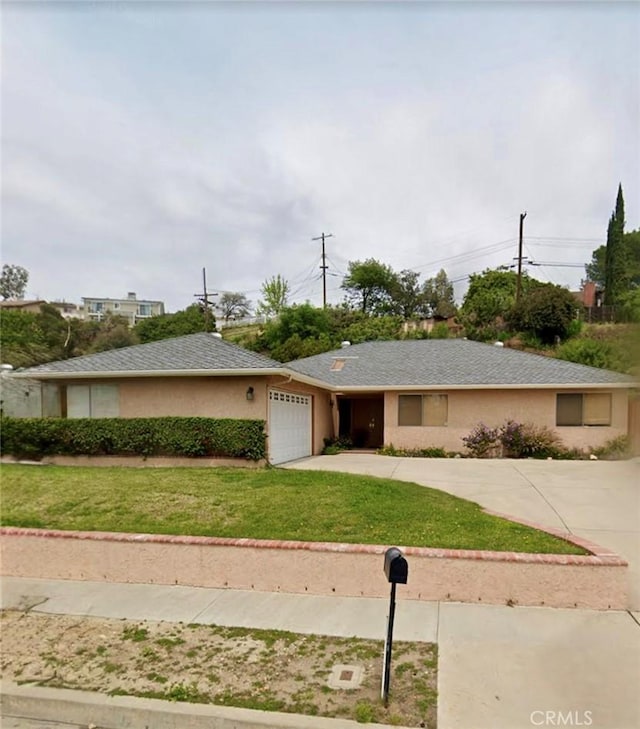 ranch-style house featuring stucco siding, a garage, concrete driveway, and a front lawn