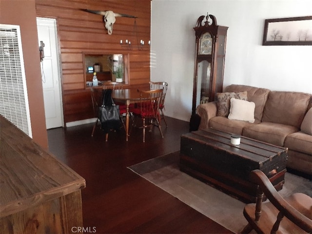 living area with wooden walls, wood finished floors, and a heating unit