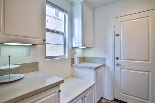 kitchen featuring light countertops, white cabinets, and a wealth of natural light