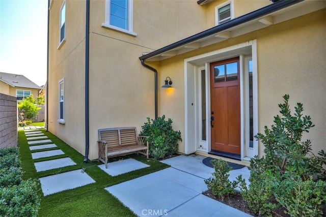 property entrance with stucco siding