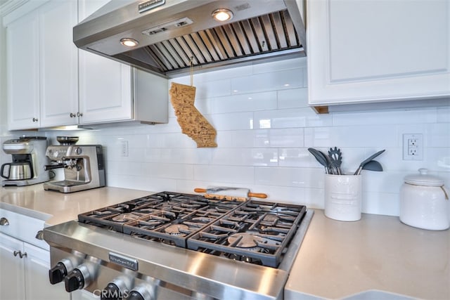 kitchen with light countertops, tasteful backsplash, stainless steel gas cooktop, exhaust hood, and white cabinets