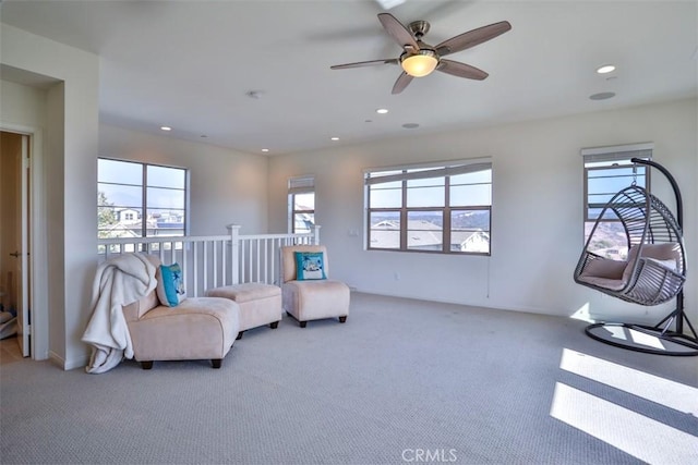 sitting room with a wealth of natural light, carpet, and a ceiling fan