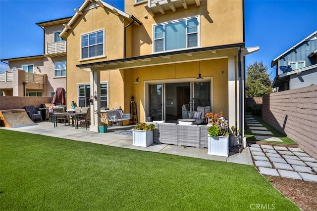 rear view of property with a patio, an outdoor living space, a fenced backyard, and stucco siding