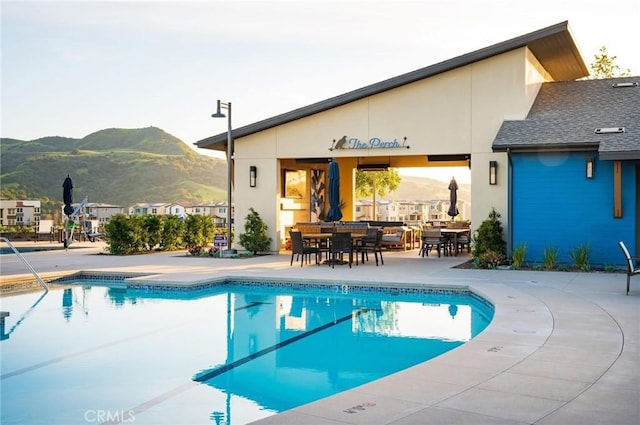 community pool with a patio and a mountain view