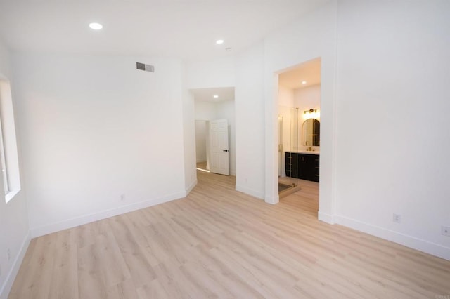 empty room with light wood-type flooring, visible vents, baseboards, and recessed lighting