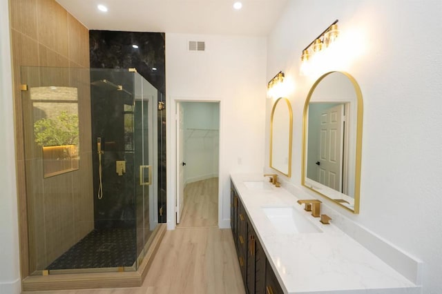 full bath with double vanity, a shower stall, visible vents, and a sink