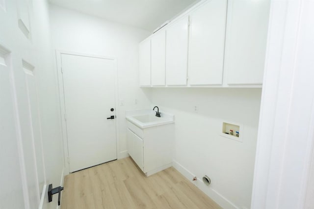 washroom featuring cabinet space, gas dryer hookup, hookup for a washing machine, light wood-style floors, and a sink