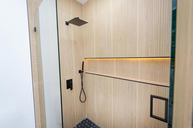 bathroom featuring elevator and a tile shower