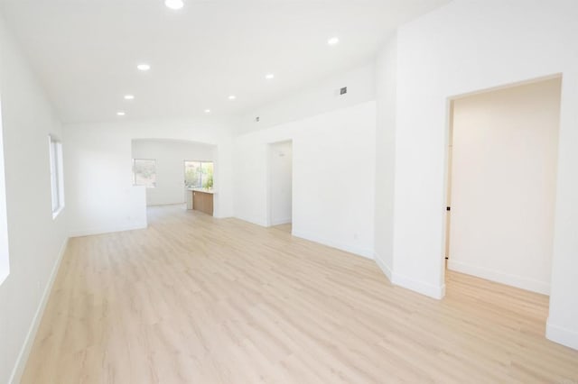 unfurnished room featuring light wood-type flooring, recessed lighting, baseboards, and lofted ceiling