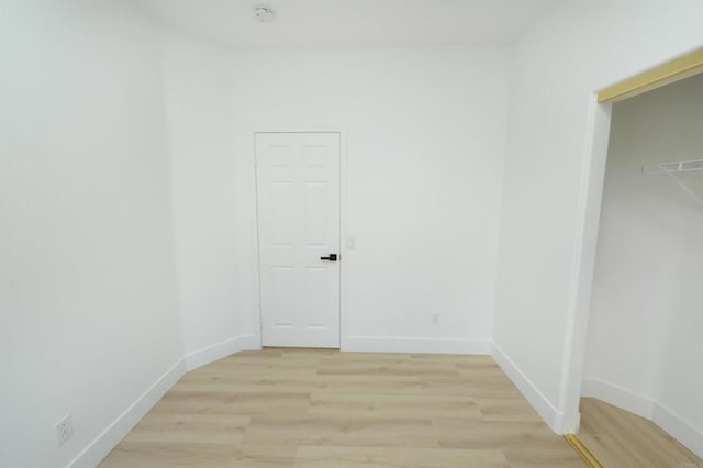 spare room featuring light wood-type flooring and baseboards